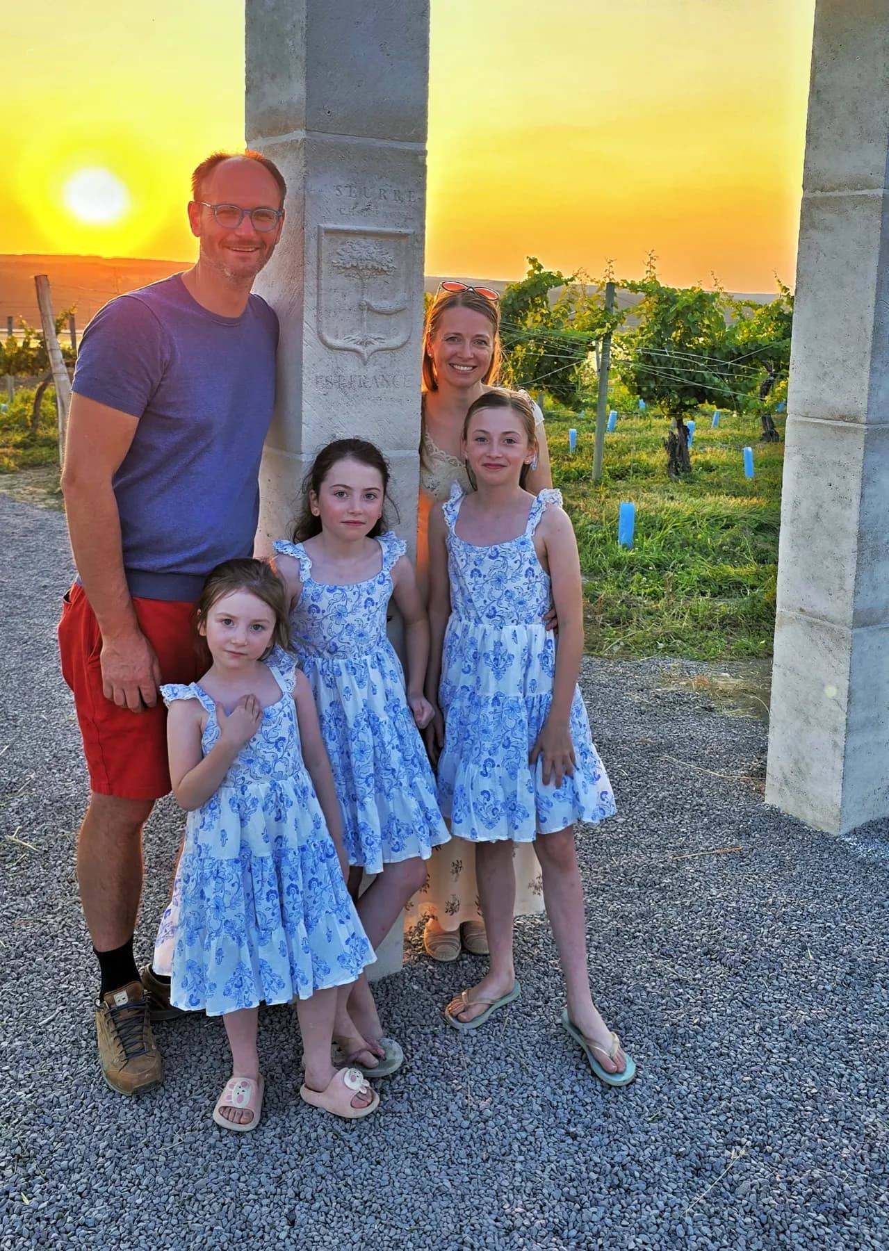 Céline and Sébastien LeSeurre with their daughters beneath the stone arch at sunset