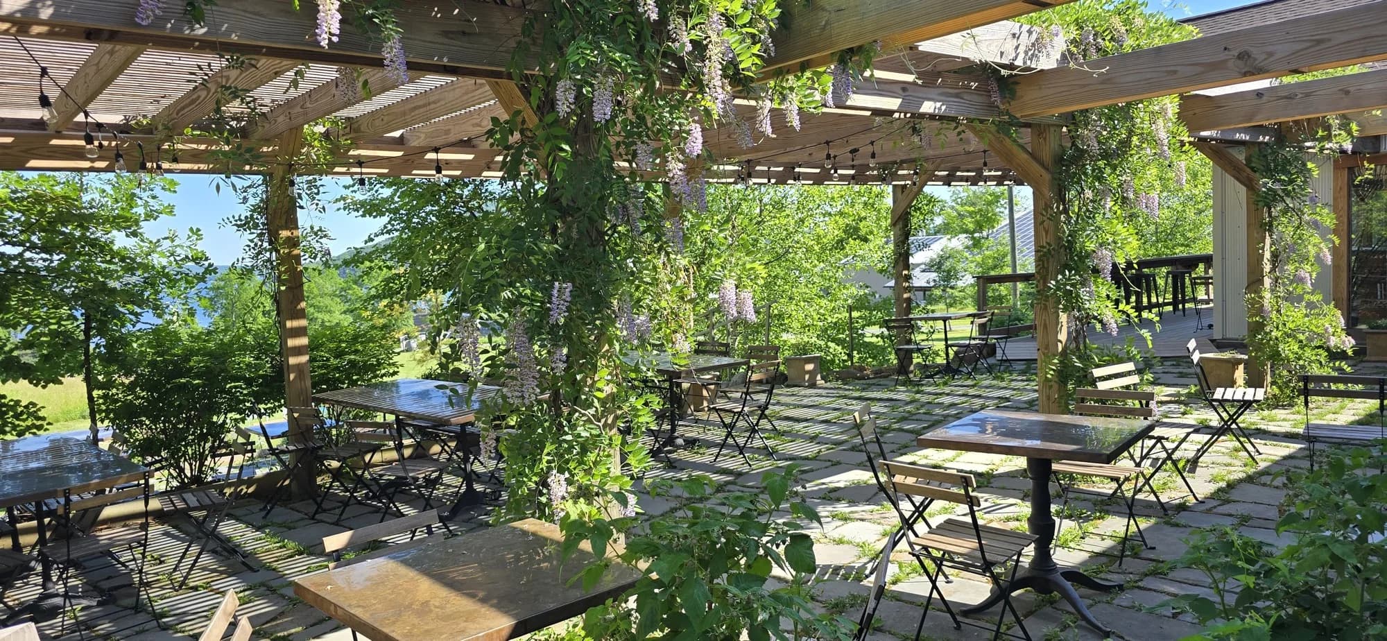 The wisteria-covered terrace with bistro tables overlooking Keuka Lake